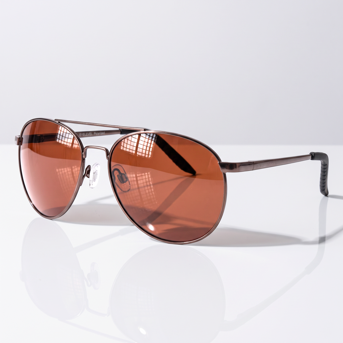 Eyelevel-UK Cabrio polarized driving sunglasses with gunmetal frames and copper lenses on a reflective surface