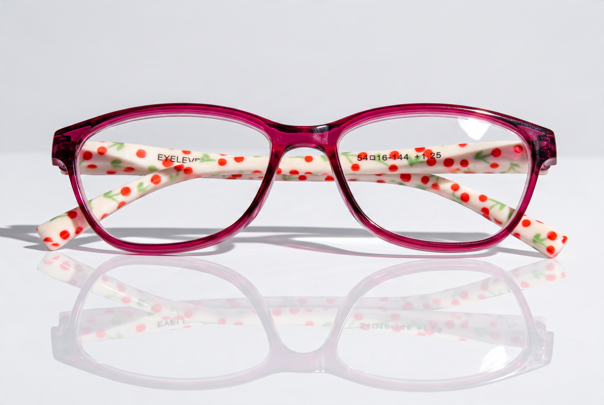 Eyelevel-UK Aruba reading glasses with bright pink rounded-square frames and white arms featuring a red cherry print.