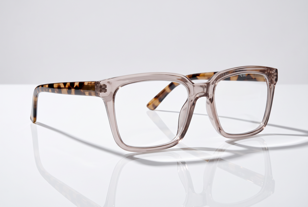 Eyelevel-UK Cayman reading glasses with a pale-pink squared frame and tortoiseshell temples on a reflective surface.