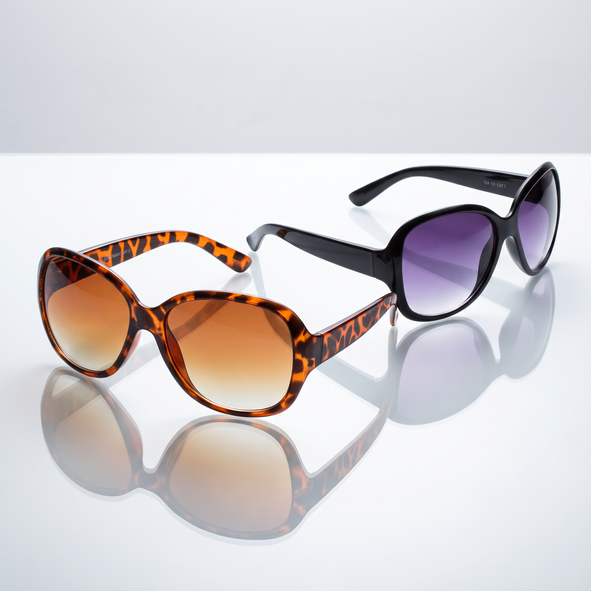 Eyelevel-UK Kate oversized ladies sunglasses in black and brown tortoiseshell with gradient lenses on reflective surface