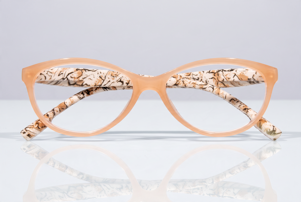 Eyelevel-UK Mexico reading glasses with a beige cat-eye frame and animal print inner temples on a reflective surface.