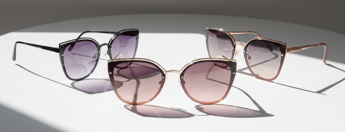 Eyelevel-UK Rosie cat-eye sunglasses in black, rose gold, and light gold with gradient lenses on a white surface