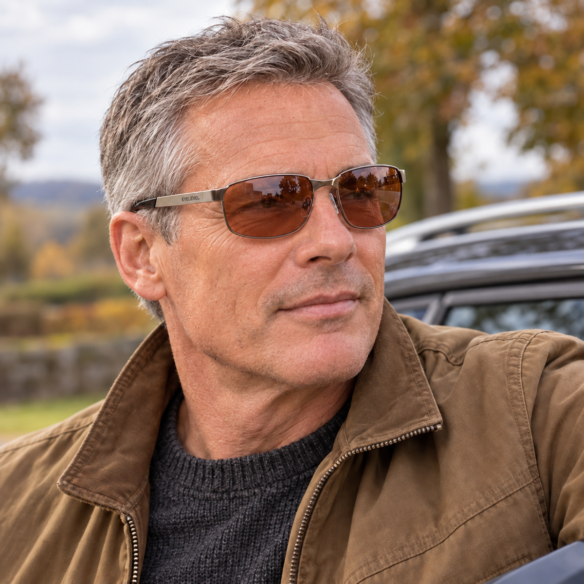 A man wearing Eyelevel-UK Stirling polarized driving sunglasses with copper lenses and a gunmetal frame outdoors.