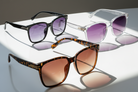 Three pairs of sunglasses with different designs and color gradients on a white background.