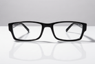 Eyelevel-UK Alfie reading glasses featuring a slim black rectangular plastic frame on a reflective white surface.