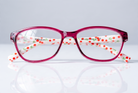 Eyelevel-UK Aruba reading glasses with a bright pink rounded-square frame and white arms featuring a red cherry print.