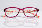 Eyelevel-UK Aruba reading glasses with bright pink rounded-square frames and white arms featuring a red cherry print.
