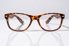 Eyelevel-UK Ashley Brown reading glasses with a rectangular tortoiseshell plastic frame on a reflective surface