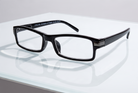 Eyelevel-UK Attorney black rectangular reading glasses with slim plastic frames on a reflective white surface