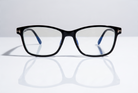 Eyelevel-UK black rectangular reading glasses with blue-light-filtering lenses on a reflective white surface.