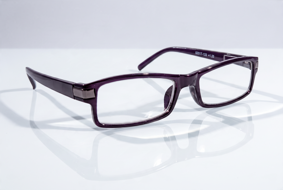 Eyelevel-UK Attorney black rectangular reading glasses with clear magnifying lenses on a reflective white surface.