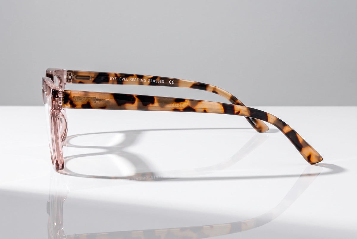 Eyelevel-UK Cayman reading glasses with a pale-pink front and tortoiseshell-patterned arms on a white surface.
