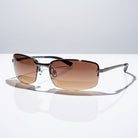 Eyelevel-UK Daytona driving sunglasses with gunmetal frames and high density brown gradient lenses on a white surface.