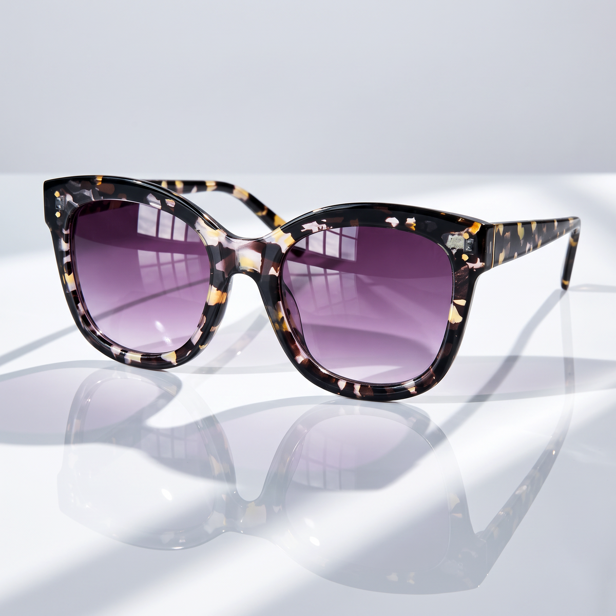 Eyelevel-UK Jessica square sunglasses with tortoiseshell frame and grey gradient lenses on a reflective surface