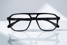 Eyelevel-UK Lancaster black square reading glasses with a double bridge design on a reflective white surface.
