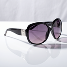 Eyelevel-UK Lucy oversized geometric sunglasses in black and silver with grey gradient lenses on a reflective surface