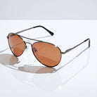 Eyelevel-UK Monte Carlo polarized driving sunglasses with gunmetal frames and copper lenses on a reflective surface.