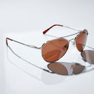 Eyelevel-UK Monte Carlo polarized driving sunglasses with silver aviator frames and copper lenses on a white surface.
