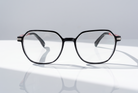 Eyelevel-UK St Kitts reading glasses with a translucent grey squared frame and patterned temples on a white surface.