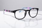 Eyelevel-UK Stripe reading glasses with black oval frames and pink and blue striped temples on a reflective surface.