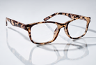 Eyelevel-UK Zante reading glasses with a brown and beige tortoiseshell square plastic frame on a reflective surface