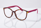 Eyelevel-UK Zurich reading glasses with tortoiseshell square frames and berry-pink temples on a reflective surface.
